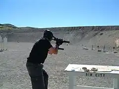 Mini Uzi being fired with magazines held together horizontally.