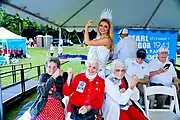 Lily K. Donaldson and three women who worked in shipyards during WW2 hold up their arms like Rosie the Riveter