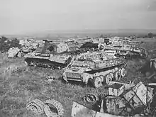 Wrecked vehicles are strewn across a field.