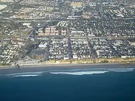 Aerial view of part of old town Encinitas showing Moonlight Beach on the left. Parallel with the shore is Historic Coast Highway 101; also parallel and further inland is Interstate 5.