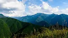 An image of the forest covered hills of Mount Omine and Mount Misen, the rolling mountains are popularly likened to the waves of the sea stretching to the horizon.