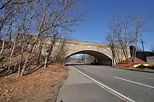 A concrete arch bridge over a four-lane roadway