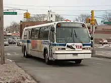 A bus in Q46 service on a large road in Kew Gardens Hills, Queens, during the winter