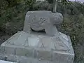 Ram-shaped grave monument embedded in concrete