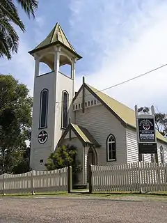 White clapboard church behind a white picket fence