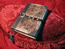 A book placed on a table lined with red velvet.