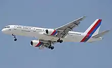 Side view of airliner in flight, with extended landing gear