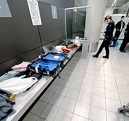 A customs officer in Amsterdam Airport Schiphol checks the luggage of an incoming traveler.