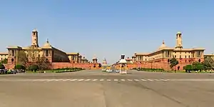 Vijay Chowk with North and South Block of the Secretariat Building in the backdrop. As one looks at the Raisina Hill buildings from Vijay Chowk, the Rashtrapati Bhavan disappears and only its dome is visible.