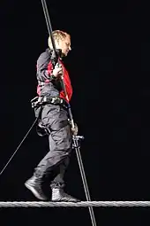 A man in black and red clothing on a tightrope