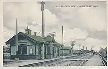 A postcard of a small green railway station