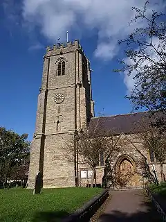 Stone building with square tower.