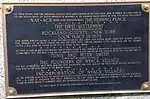 A history plaque, mounted on the Burd Street side of the bank building located on South Broadway & Burd Street in Nyack. The inscription says "Nay-ACK, which being translated means THE FISHING PLACE...The First Settlement ...Rockland County, NY...took place in 1675."