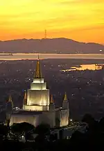 San Francisco's three pronged Sutro Tower on a mountain in the distance, with the Oakland Califorina Temple visible in the foreground.