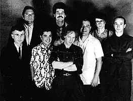 Oingo Boingo in 1987. From left to right: Dale Turner, Sam "Sluggo" Phipps,  John Avila, Steve Bartek, Danny Elfman, Johnny "Vatos" Hernandez, Mike Bacich, Leon Schneiderman.