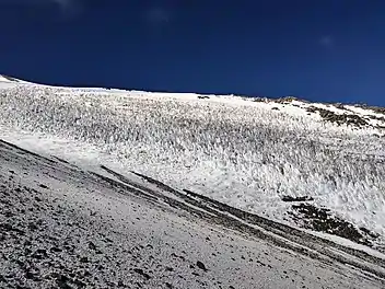 Tooth-like snow forms on a medium-steep slope of a mountain