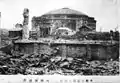 The arena is seen with heavy damages and is circled by ruins after an earthquake