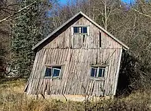 A wood-framed clapboard house, the walls WAY out of plumb.