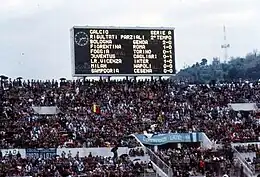 A large scoreboard above a large grandstand