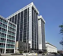 A tall, white, steel-framed building with black windows.