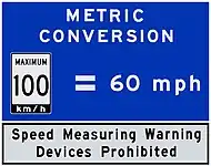 A blue metric reminder signage used in Ontario, Canada is seen near the US borders.