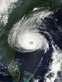 A satellite image of a well-organized hurricane featuring a circular area of clouds with a partially cleared eye in the middle.