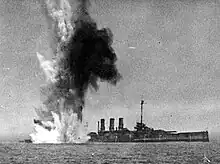 The ship already settling by the stern, another bomb explodes underwater