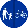 C-13/16 sign indicating compulsory track for pedestrians and bicycles – pedestrians on left, cyclists on right