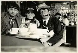 Moïse Kisling with fashion model Paquerette and Pablo Picasso, photographed by Jean Cocteau in 1916 at Café de la Rotonde, 105 Boulevard du Montparnasse, August 1916