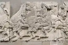 A Greek sculpture showing cavalrymen riding right to left in procession