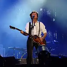 McCartney on stage playing guitar and singing