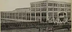 A monochromatic image of a large shopping arcade behind a viaduct