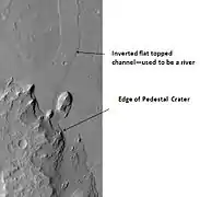 Pedestal Crater and ridge in Oxia Palus quadrangle, as seen by HiRISE. Click on image to see detail of the edge of the pedestal crater. The flat-topped ridge near the top of the image was once a river that became inverted. The pedestal crater superposes the ridge, so it is younger.