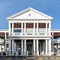 Front façade of a white Palladian-style courthouse prominently featuring columns supporting the pediment and entablature.