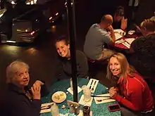 Three women sitting at a picnic table in the Sci-Fi Dine-In