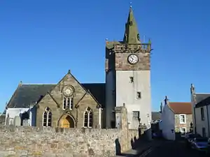 coloured photo of church and adjoining steeple with inset clock