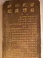 A stele with Chinese characters inside the temple.