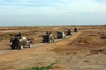 A convoy for the Polish CIMIC group (Civilian Military Cooperation) heads to an elementary school in Ad Diwaniyah, Iraq on January 19, 2005. They are going to deliver school supplies and toys.