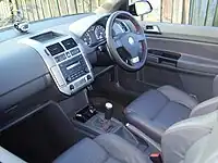  Dashboard of a car with a manual gearbox, compact disc player, front airbags, electric windows, rotary stereo and heater controls, and analogue and digital gauges