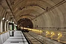 Ballastless track of the type "Low Vibration Track" with rails fixed to concrete ties/sleepers that are set in a concrete slab in the Gotthard Base Tunnel's Sedrun multifunction station.