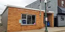 a small one-story brick building with sign reading "United States Post Office, Strum, Wisconsin