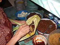 Preparing nasi kuning Manado in a woka leaf