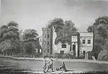 Burnt-out shell of a house in the background with three people in the foreground