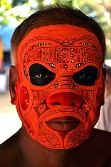 Close-up photograph of an adult male's face, covered in make-up.