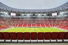 Photograph of a modern football stadium's interior; the stands are full of spectators