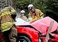 Raleigh firefighters work on dismantling a car.