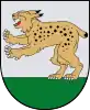 A coat of arms depicting a golden lynx with black spots, a red tongue, white teeth, and white claws standing on its back paws on green turf