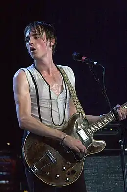 A man performing onstage with a guitar