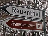 Direction signs for a minor route to a destination (white) and tourist attraction (brown) in Switzerland