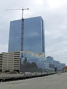 A picture showing a high blue building next to a road